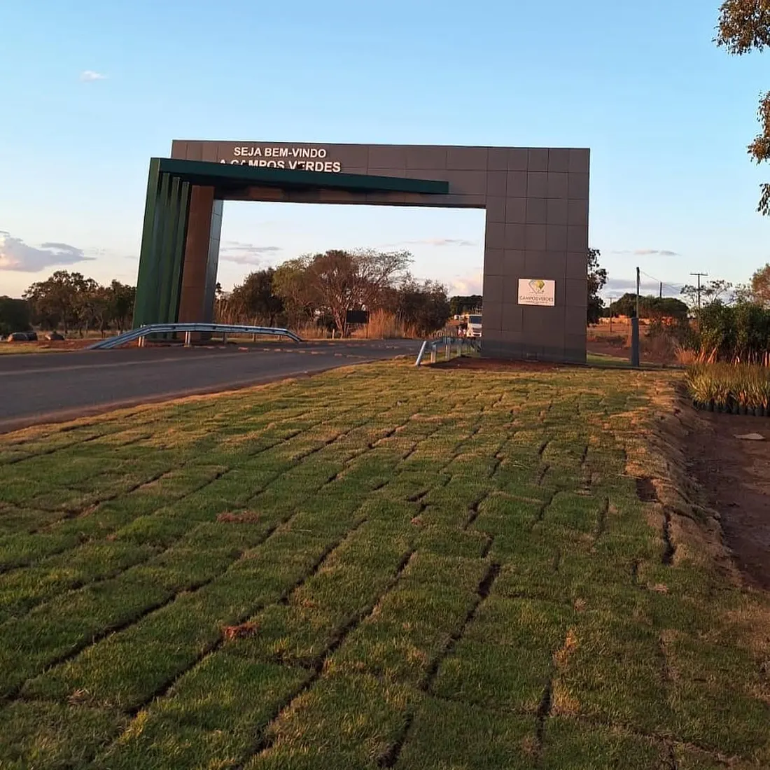 Pórtico de entrada de Campos Verdes com gramado novo em placas ao redor