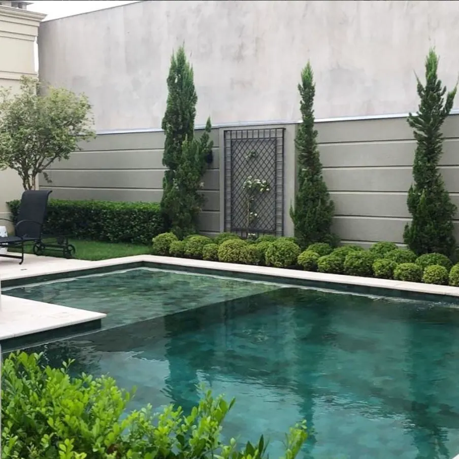 Piscina com jardim formal, ciprestes alinhados e buchinhos aparados